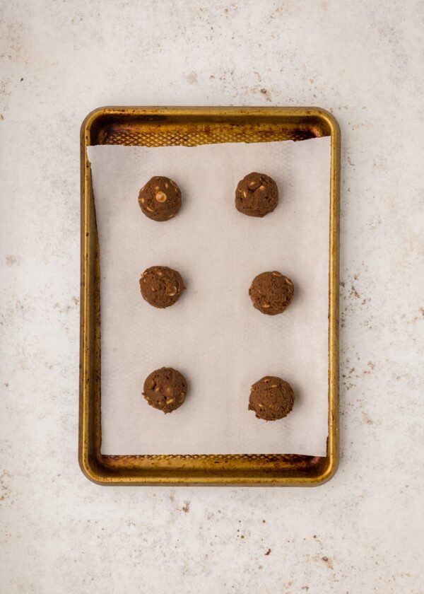rounded balls of cookie dough on a cookie sheet.