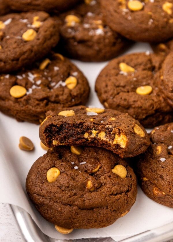 pile of chocolate cookies with peanut butter chips with a bite taken out of one.