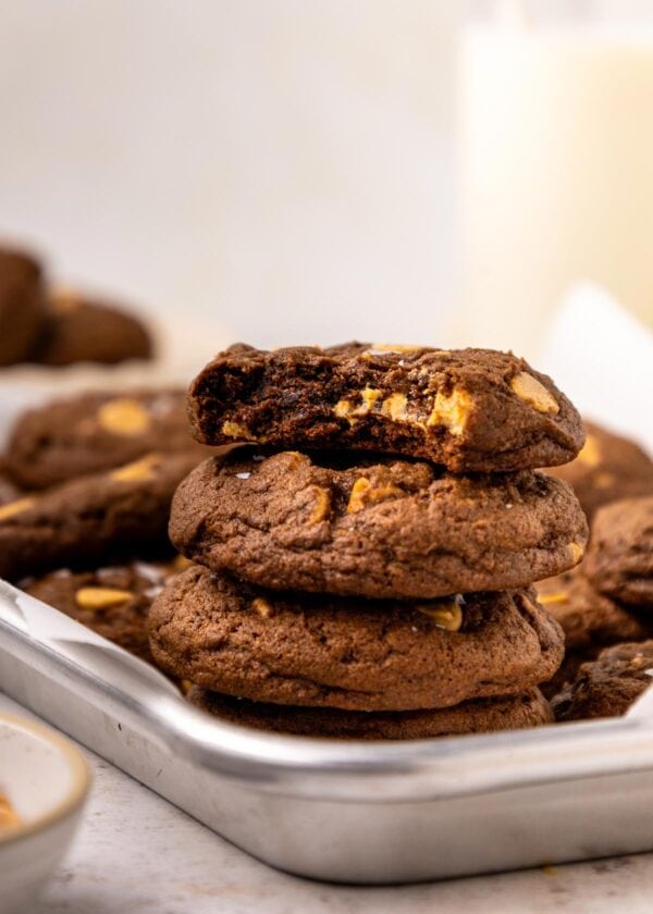 stack of chocolate peanut butter cookies with a bite taken out of the top cookies.
