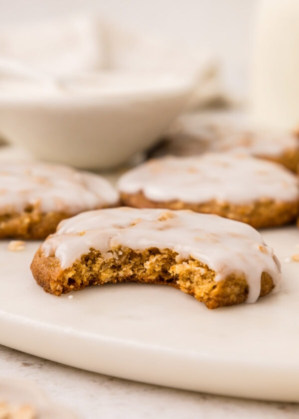 side view of a glaze oatmeal cookie with a bite taken out of it.