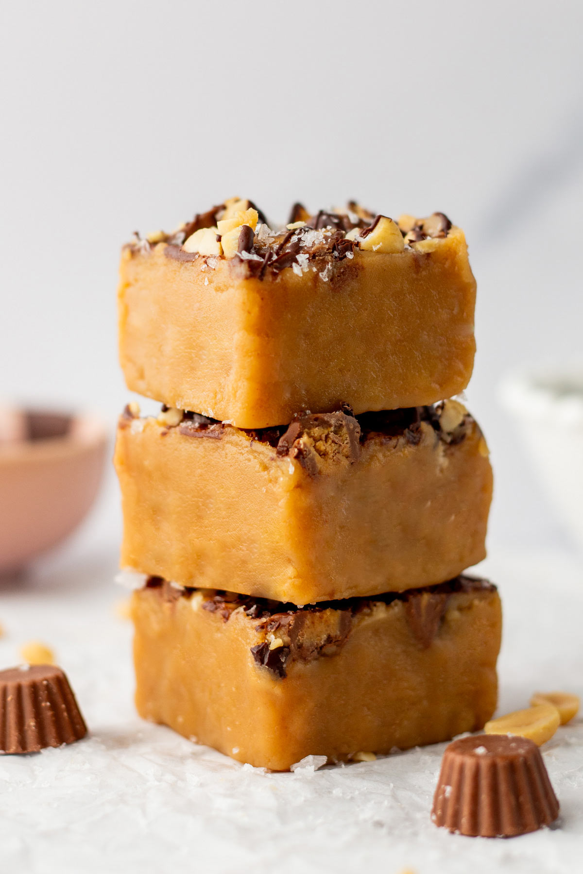stack of three squares of peanut butter fudge with drizzled chocolate.
