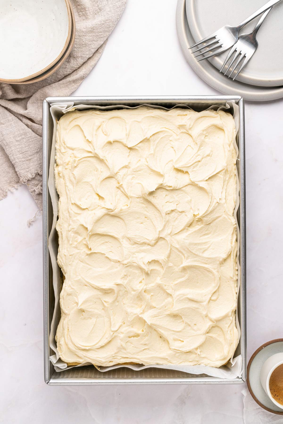 vanilla sheet cake covered with swirls of fluffy vanilla frosting.