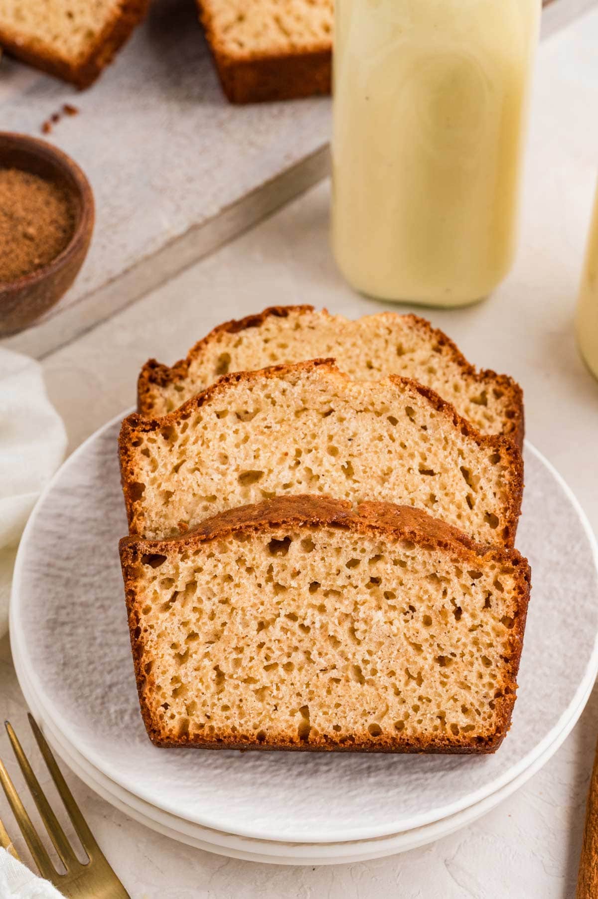 three slices of eggnog bread on a dessert plate.