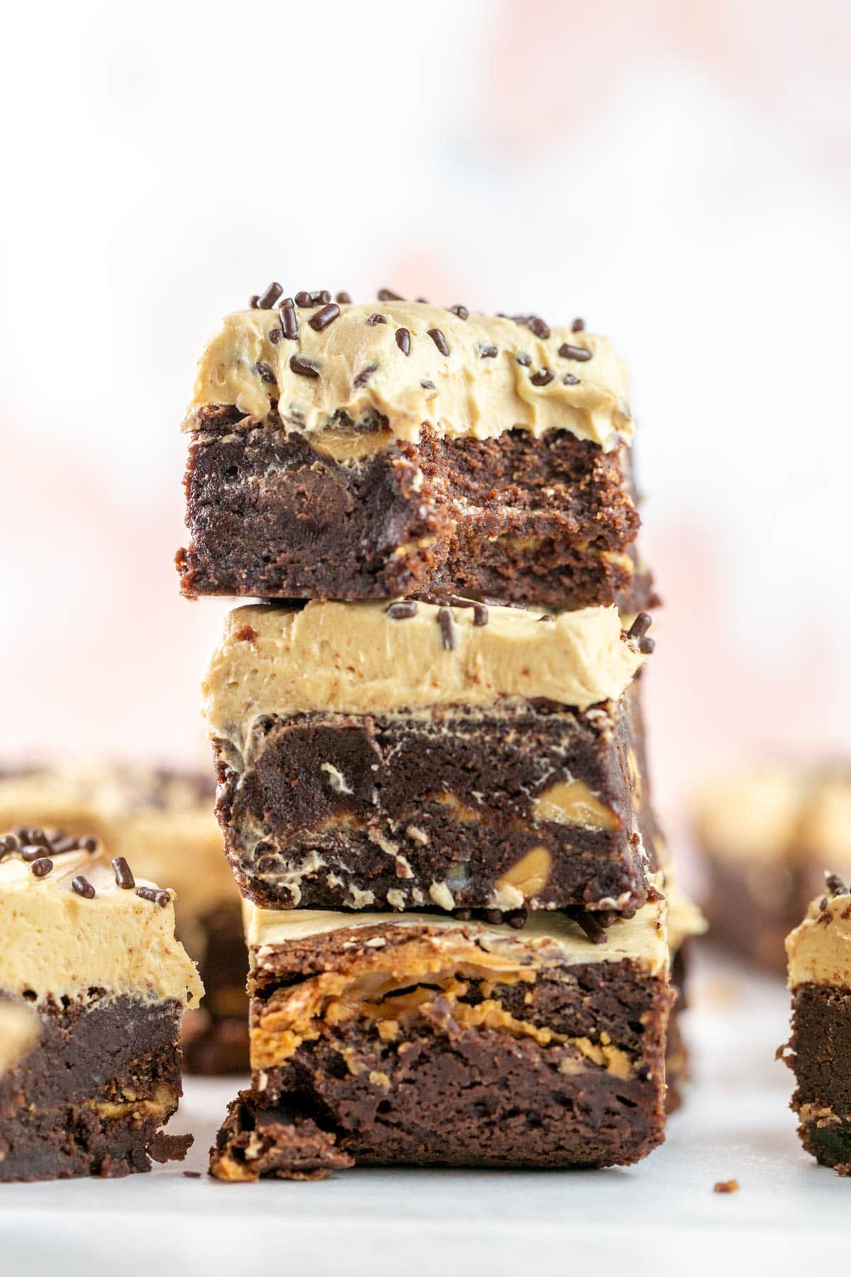 stack of three brownies with a thick layer of creamy peanut butter frosting.