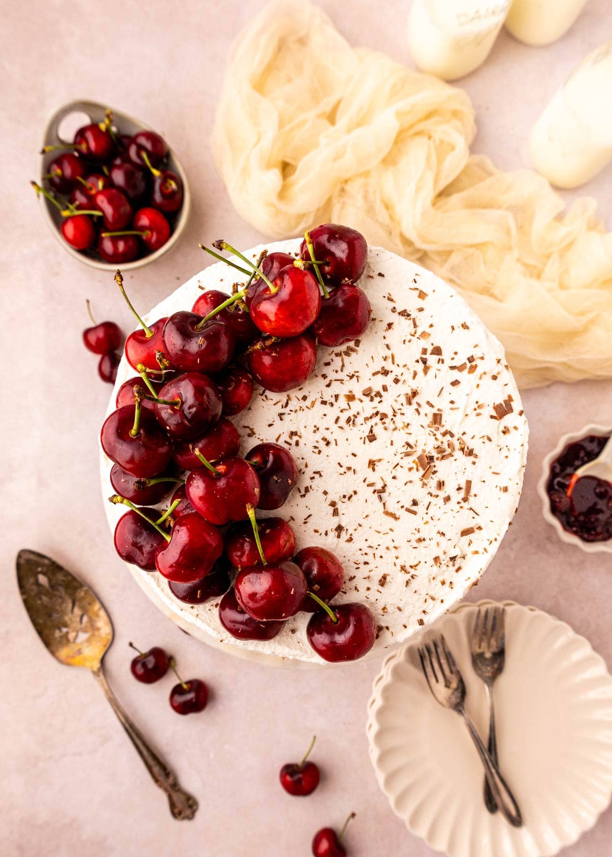 top view of a layer cake decorated with fresh cherries.