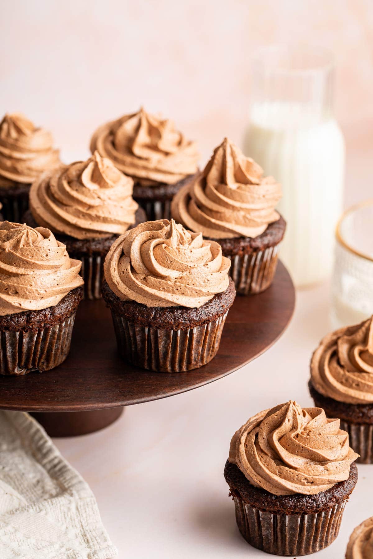 dark chocolate cupcakes on a wooden cake stand.