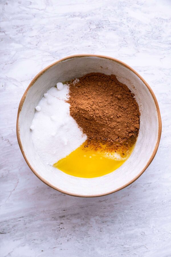 melted butter, sugar, and cocoa powder in a mixing bowl.