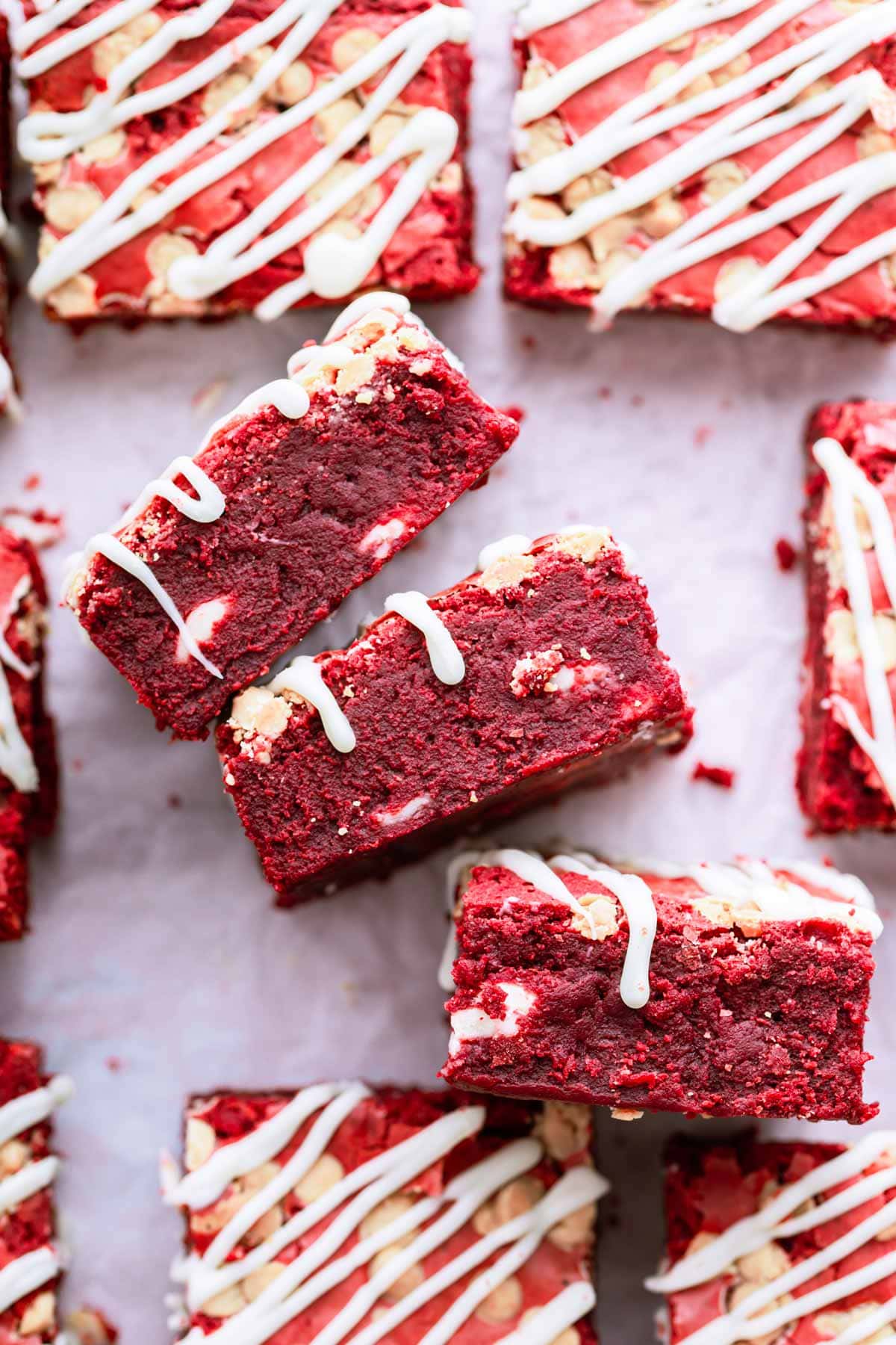 deep red thick brownies with white chocolate drizzle.