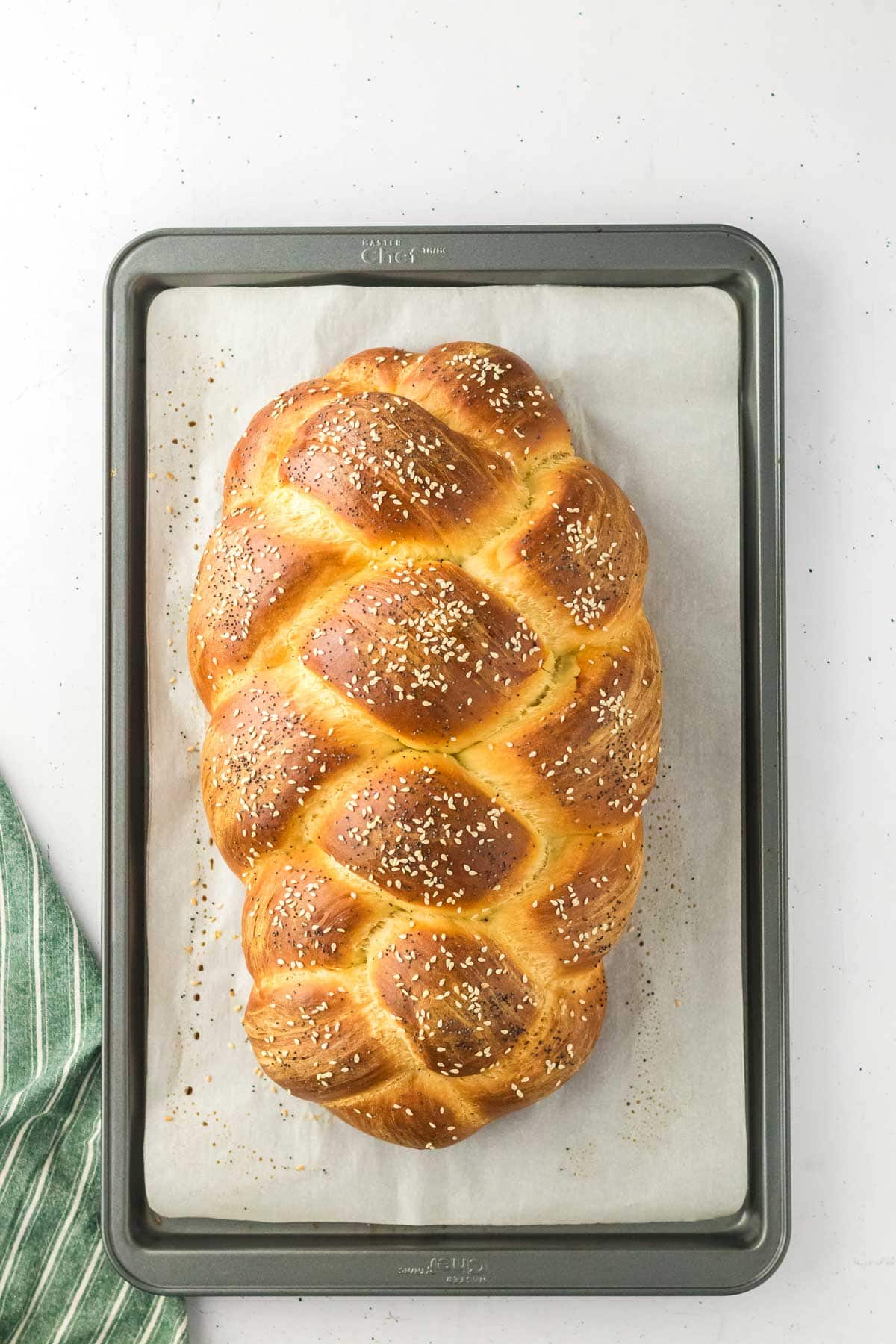 freshly baked challah topped with poppy seeds and sesame seeds.