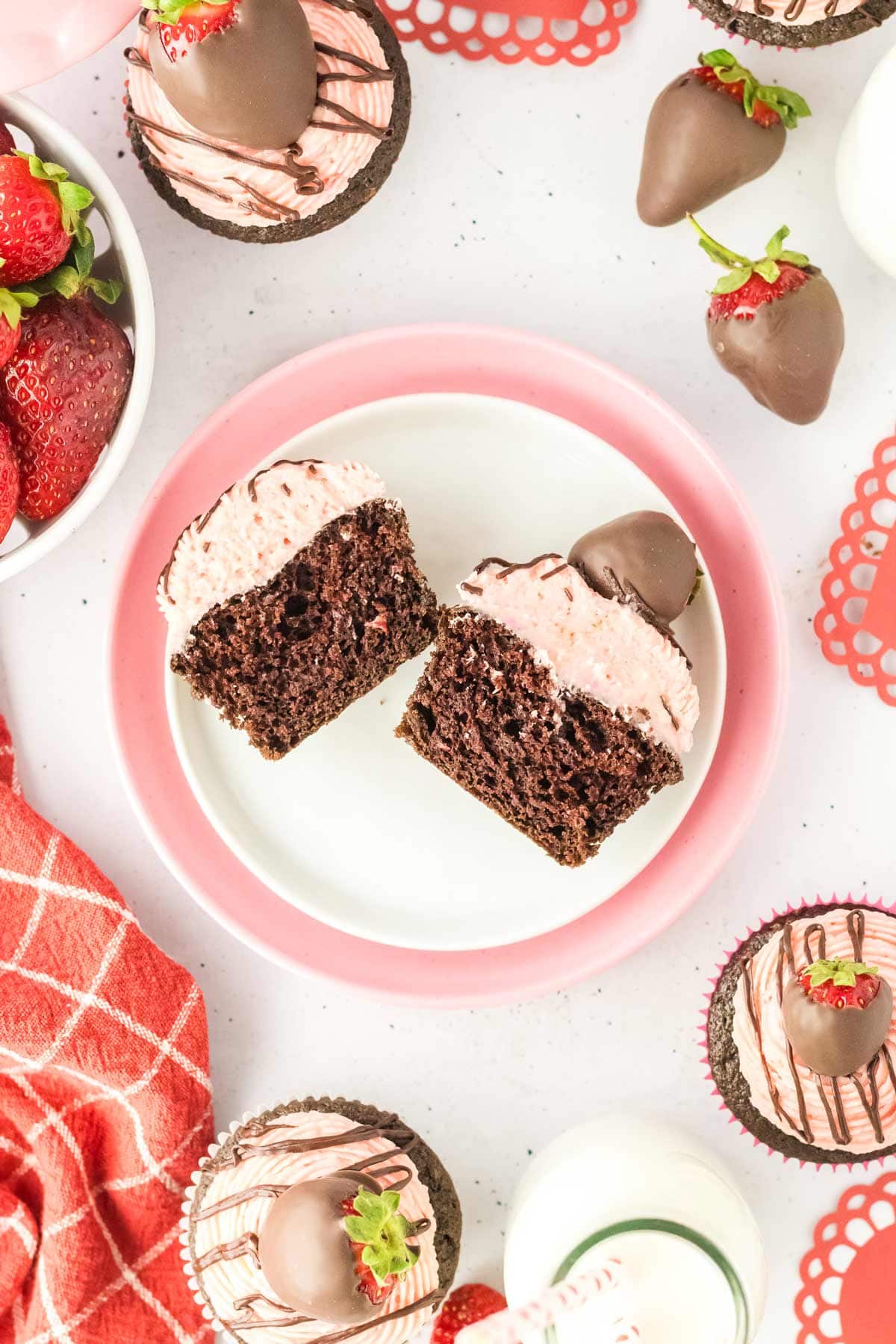 overhead view of a chocolate strawberry cupcake cut in half showing the diced strawberries inside.