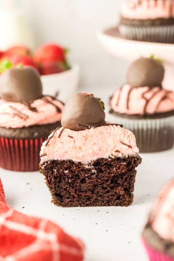 side view of a chocolate strawberry cupcake cut in half.