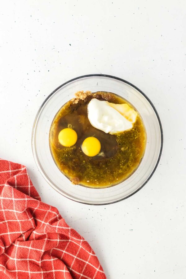 glass mixing bowl filled with wet ingredients to make cupcakes.