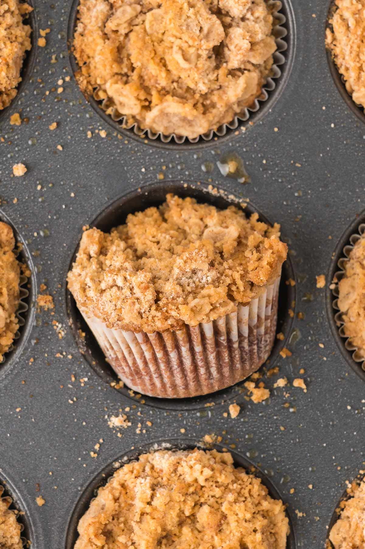 streusel topped muffin in the baking tin showing the crumbly, golden streusel.
