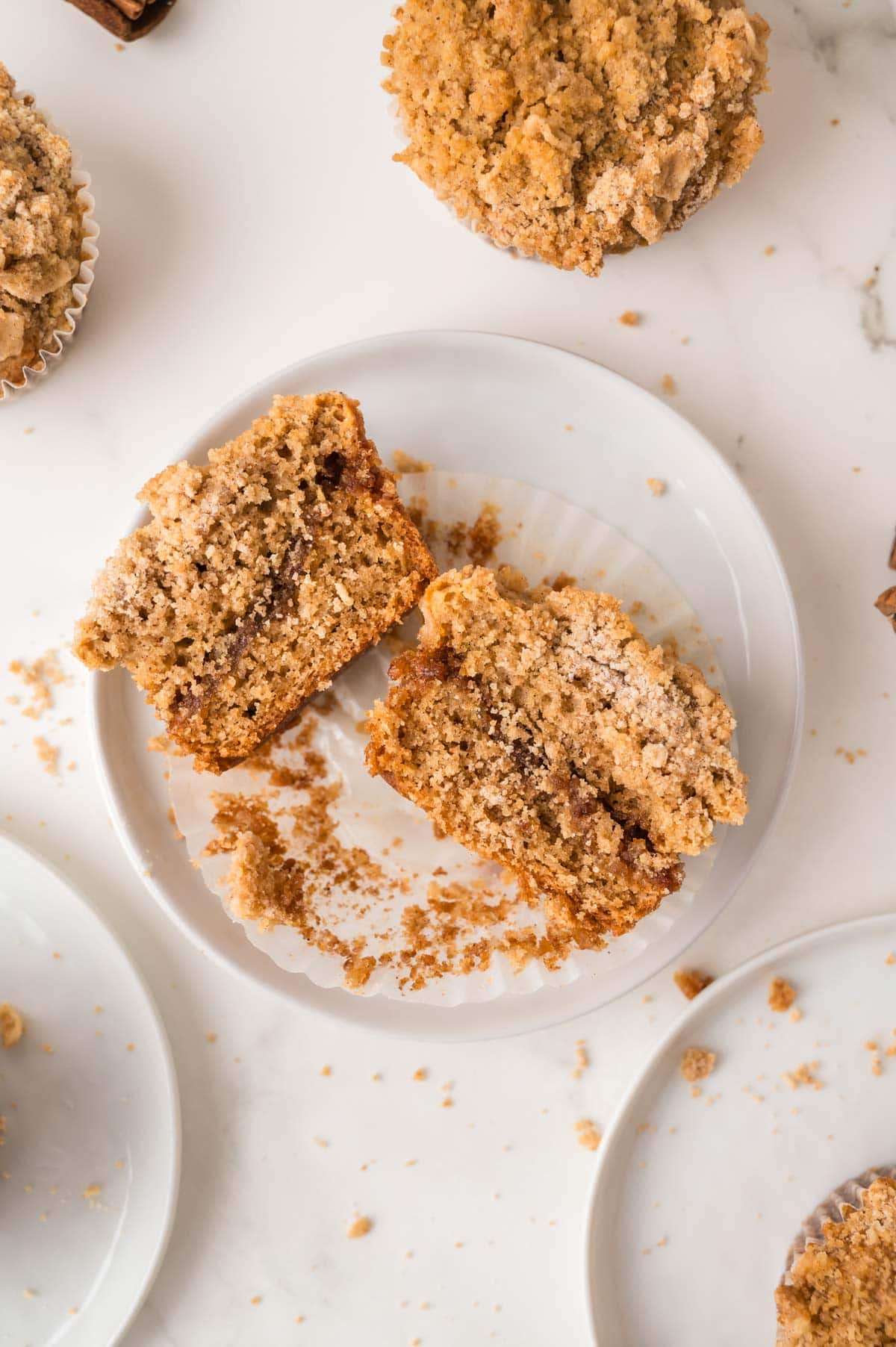 coffee cake muffin cut in half highlighting the ribbon of cinnamon running through the middle.