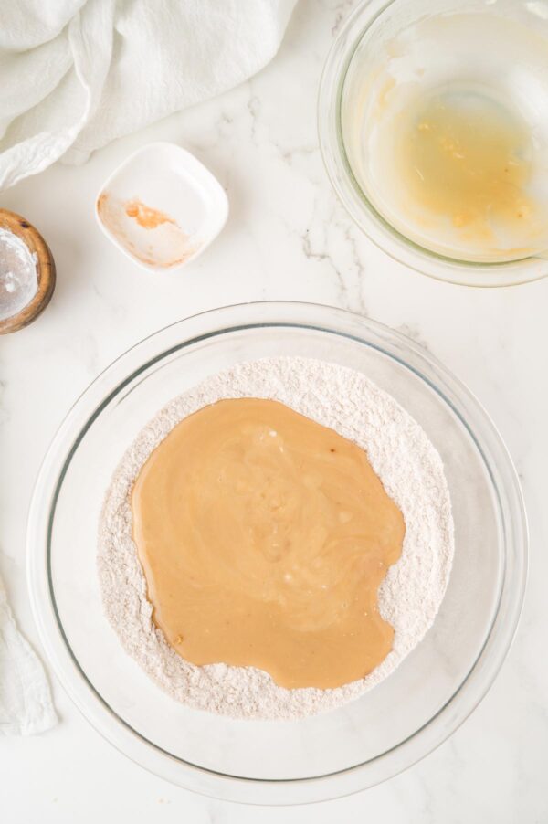 adding liquid ingredients to dry ingredients to make muffins.