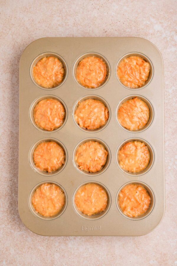 unbaked carrot muffins in a cupcake tin.