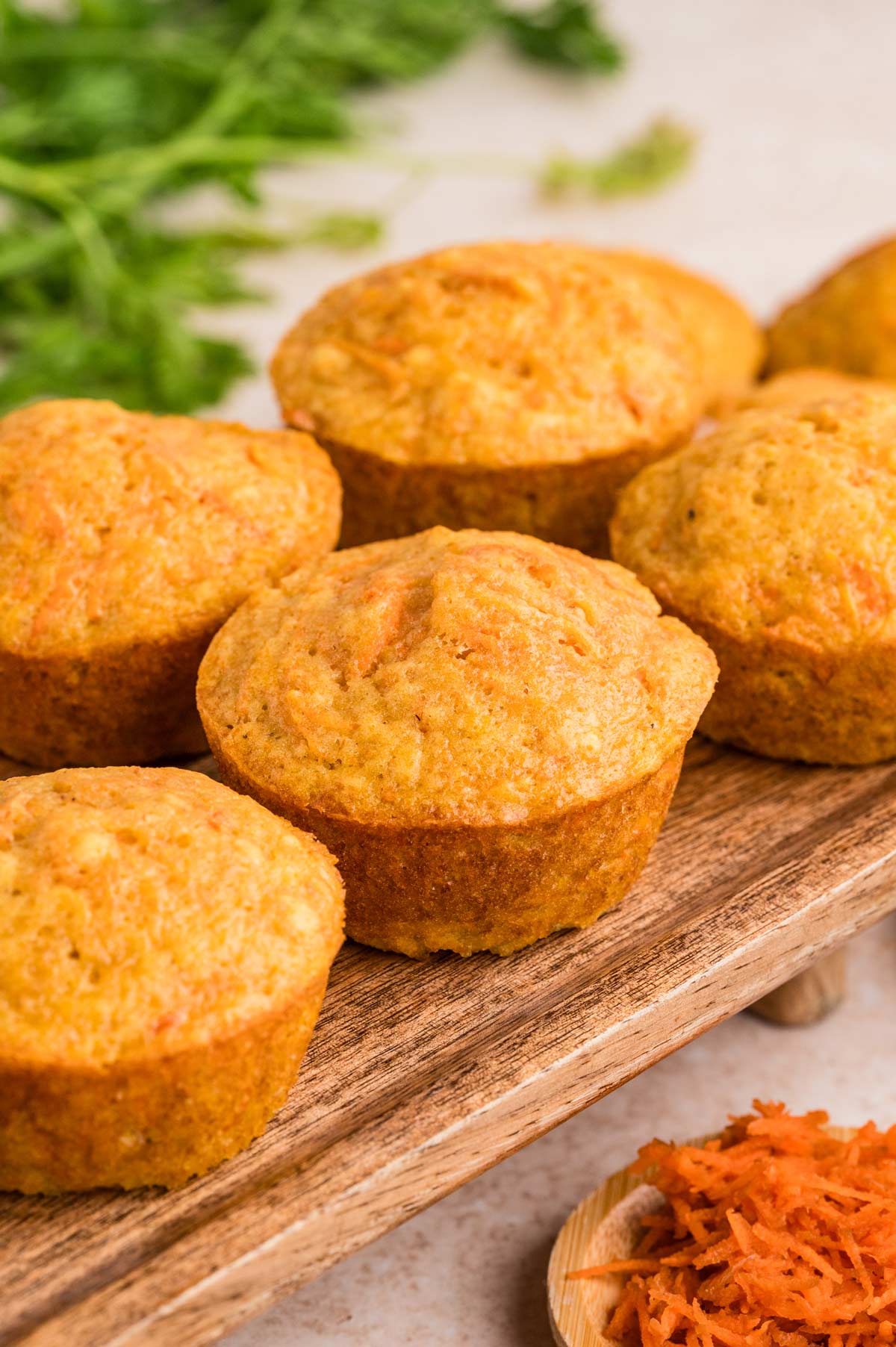 side view of lightly spiced carrot muffins on a cutting board.