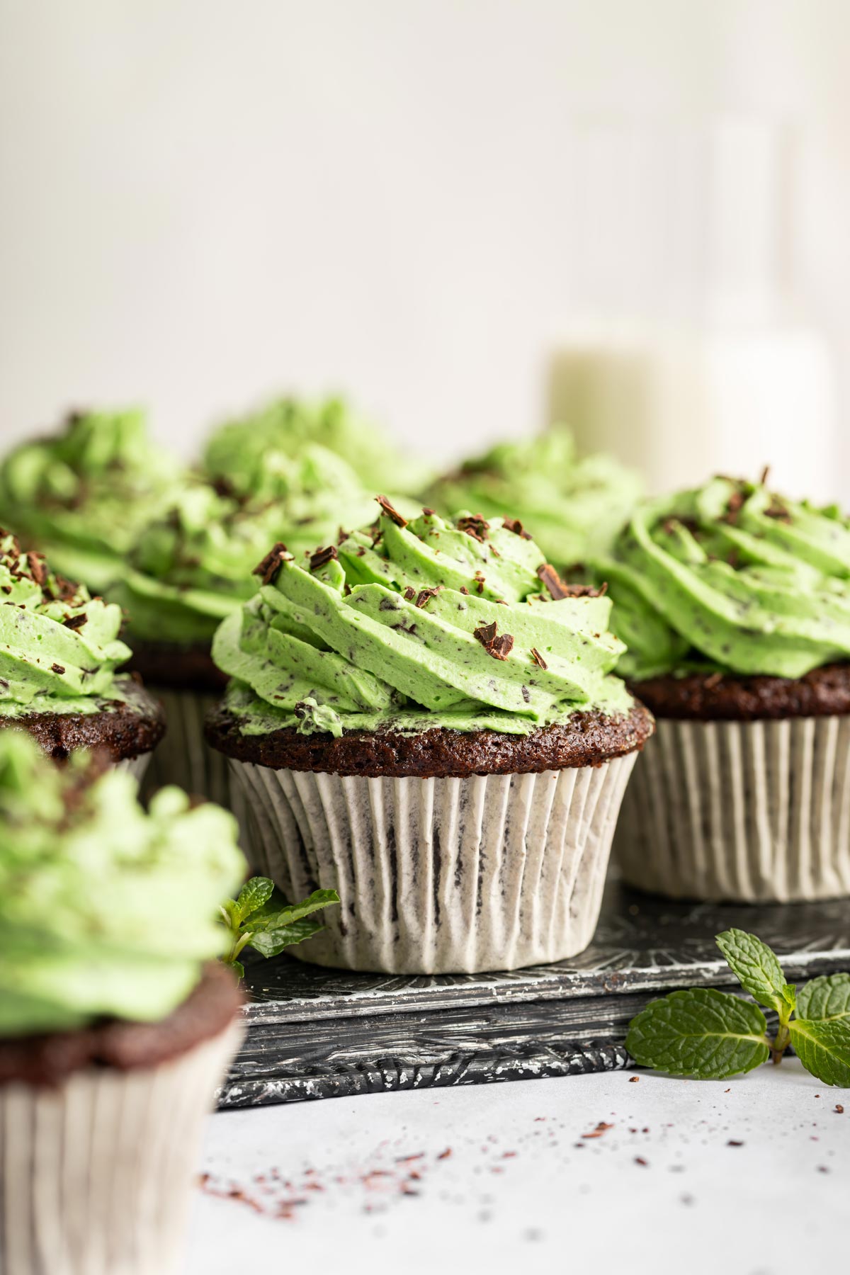 mint chocolate cupcakes with piped mint chip frosting and chopped chocolate.