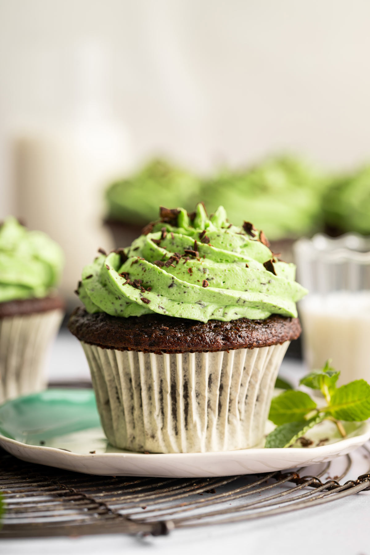 side view of a single mint chocolate cupcake on a dessert plate.