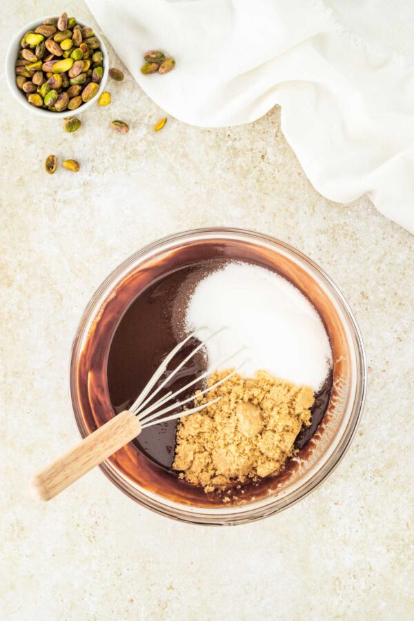 whisking sugar into melted butter and chocolate.