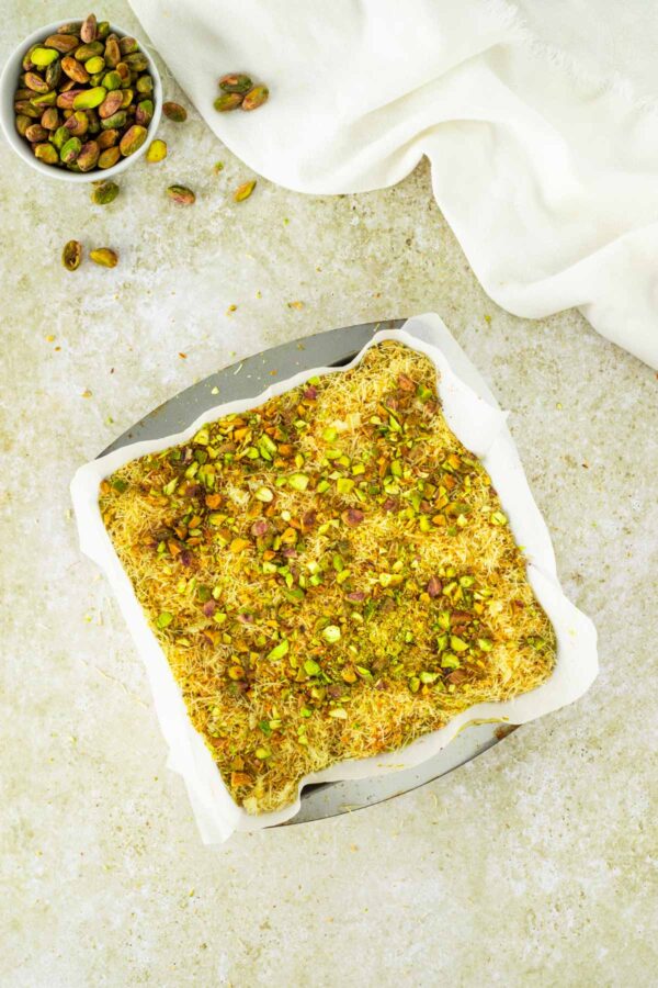 chopped pistachios scattered on the kataifi crunch layer.