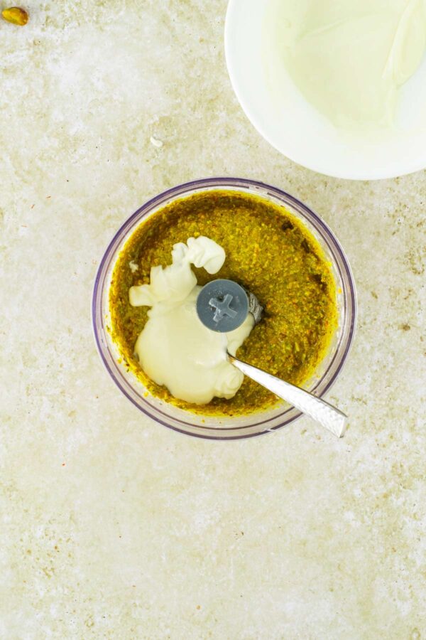 adding melted white chocolate to pistachio cream.