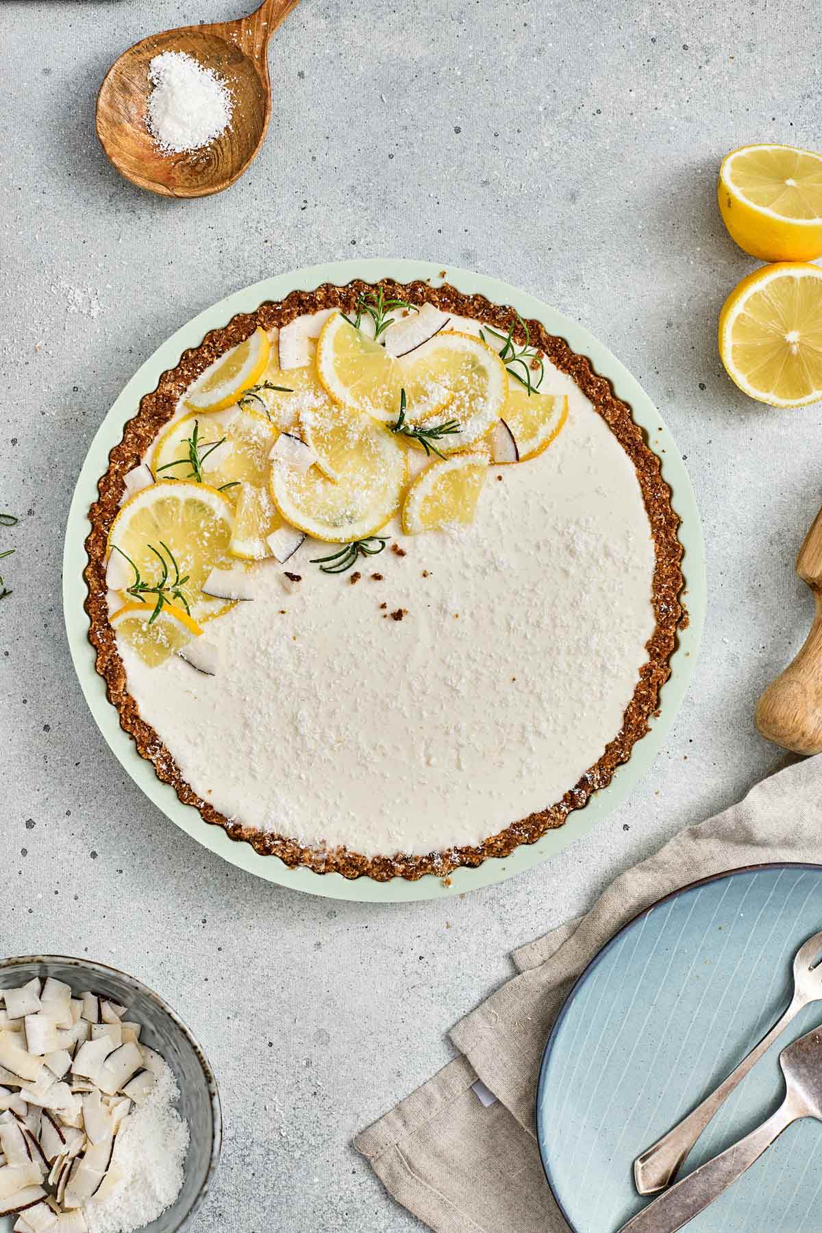 no bake lemon tart decorated with lemon slices and rosemary.