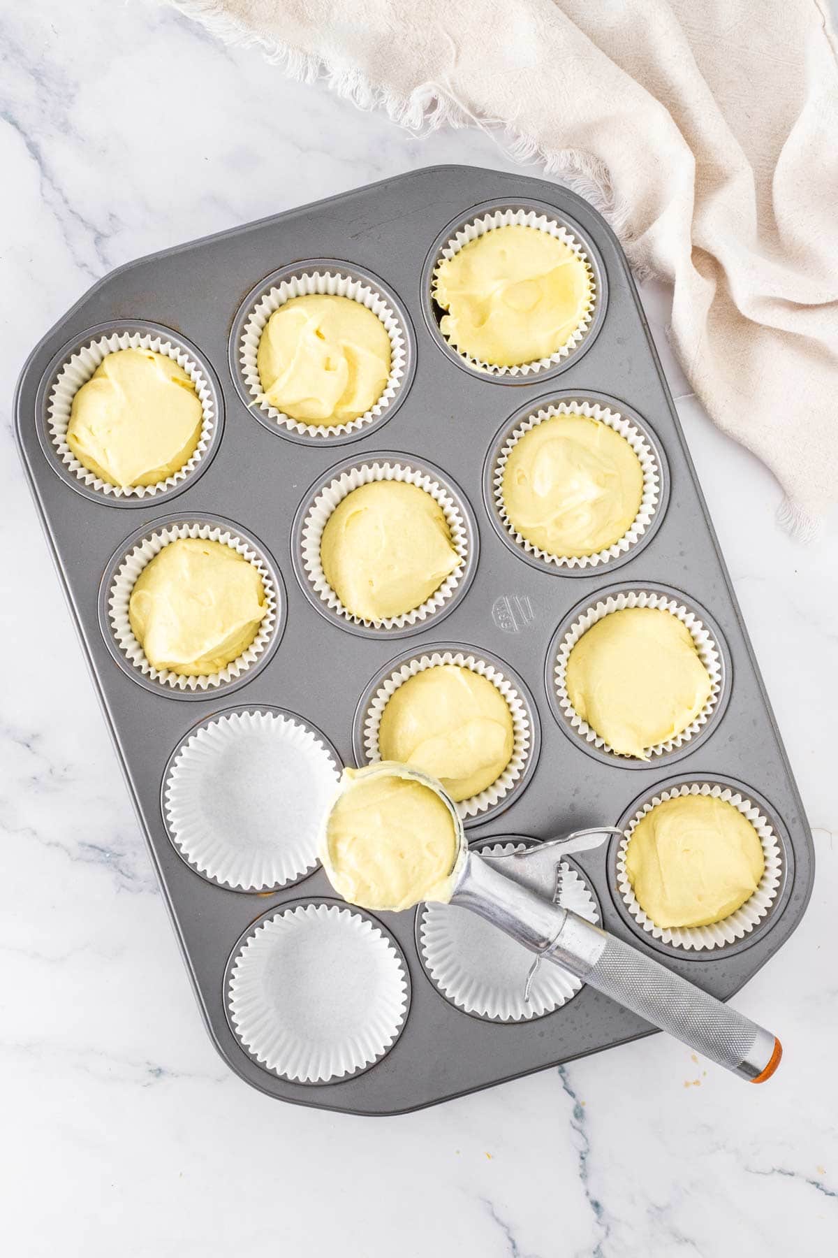 cupcake batter scooped into paper muffin liners.