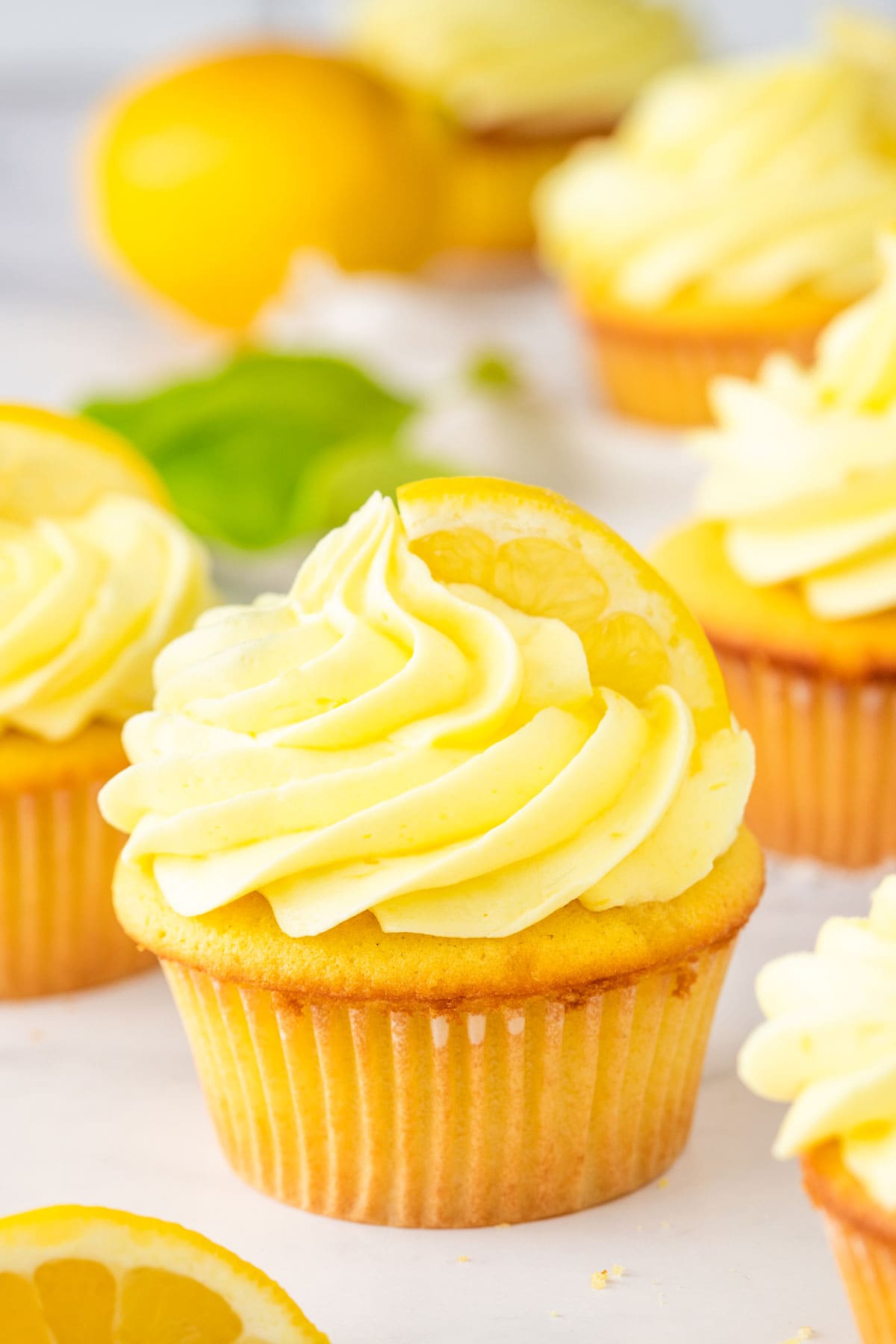 cupcakes decorated with swirls of yellow lemon cream cheese frosting.