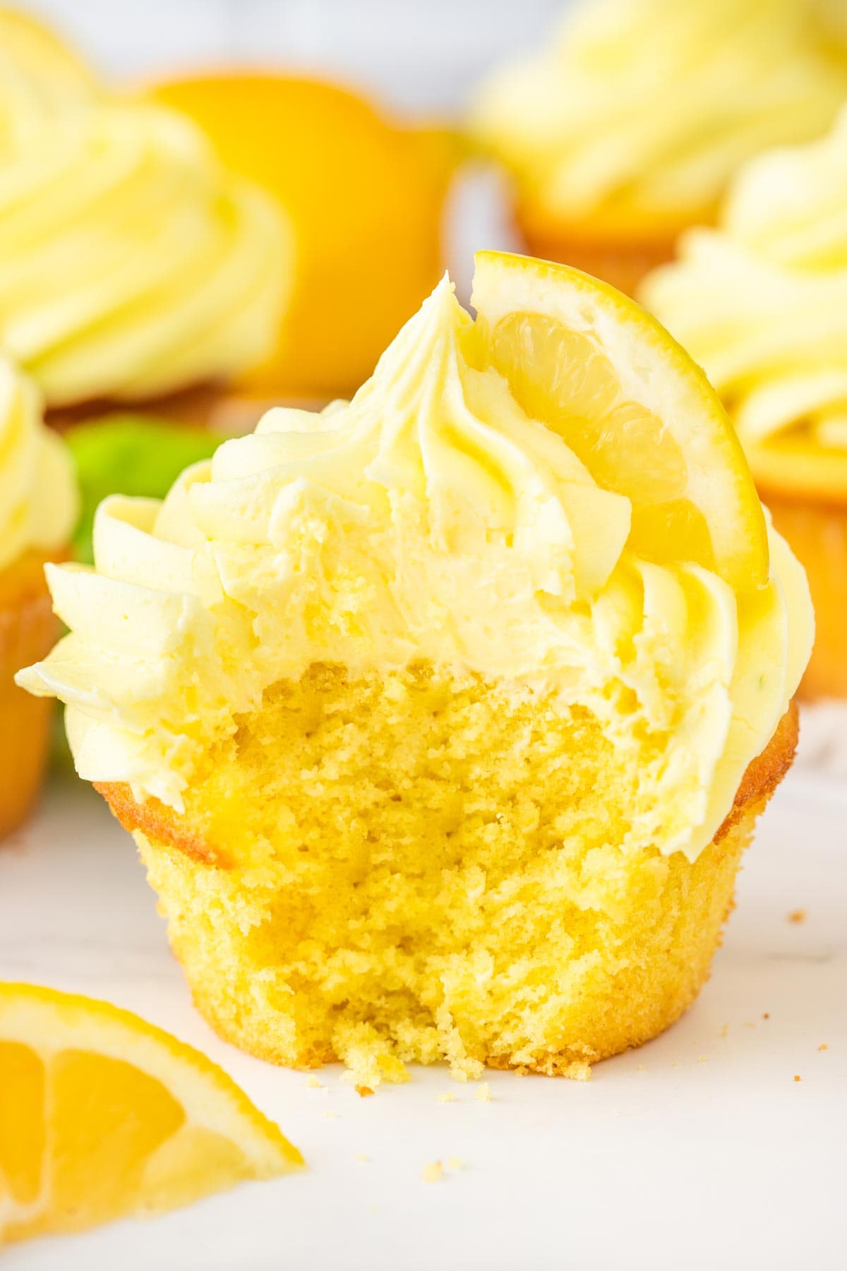 lemon cupcake with a bite removed showing the fluffy interior.