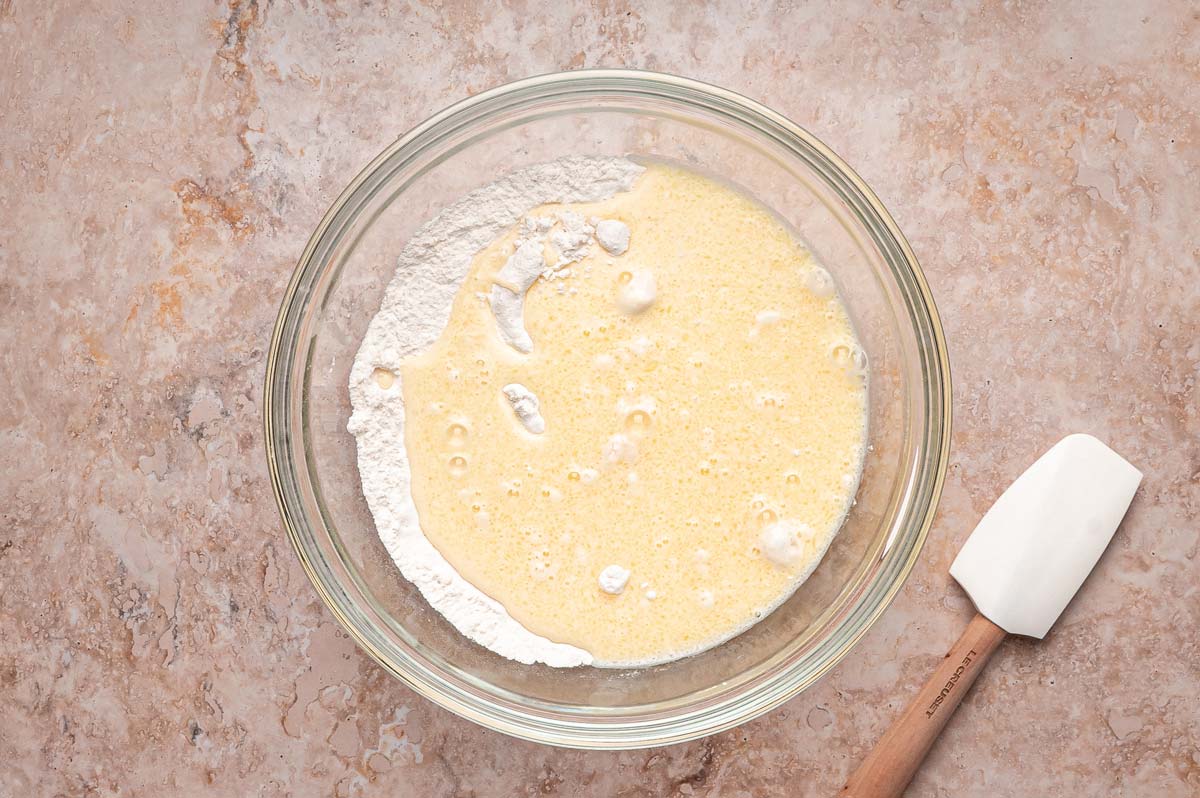 combining wet and dry ingredients to make pancake batter.