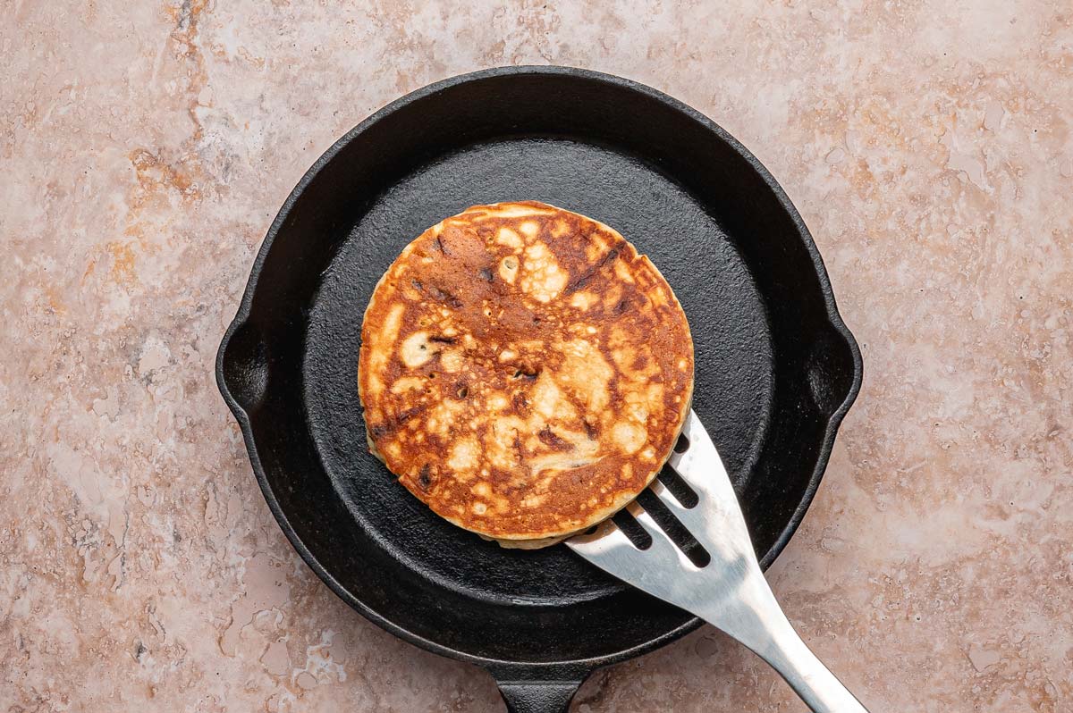 cooking a pancake in a cast iron skillet.