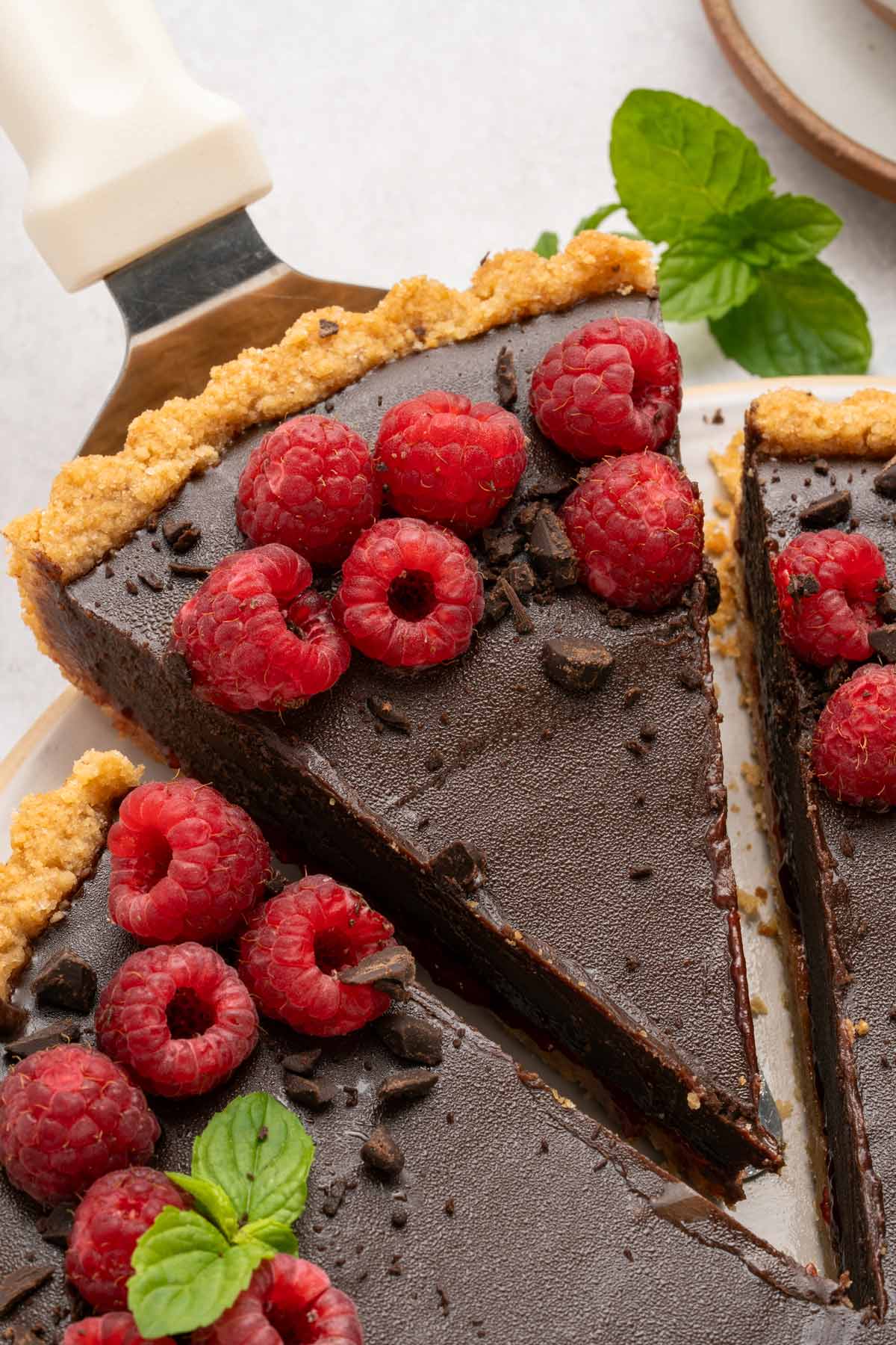 close up view of a slice of a chocolate raspberry tart.
