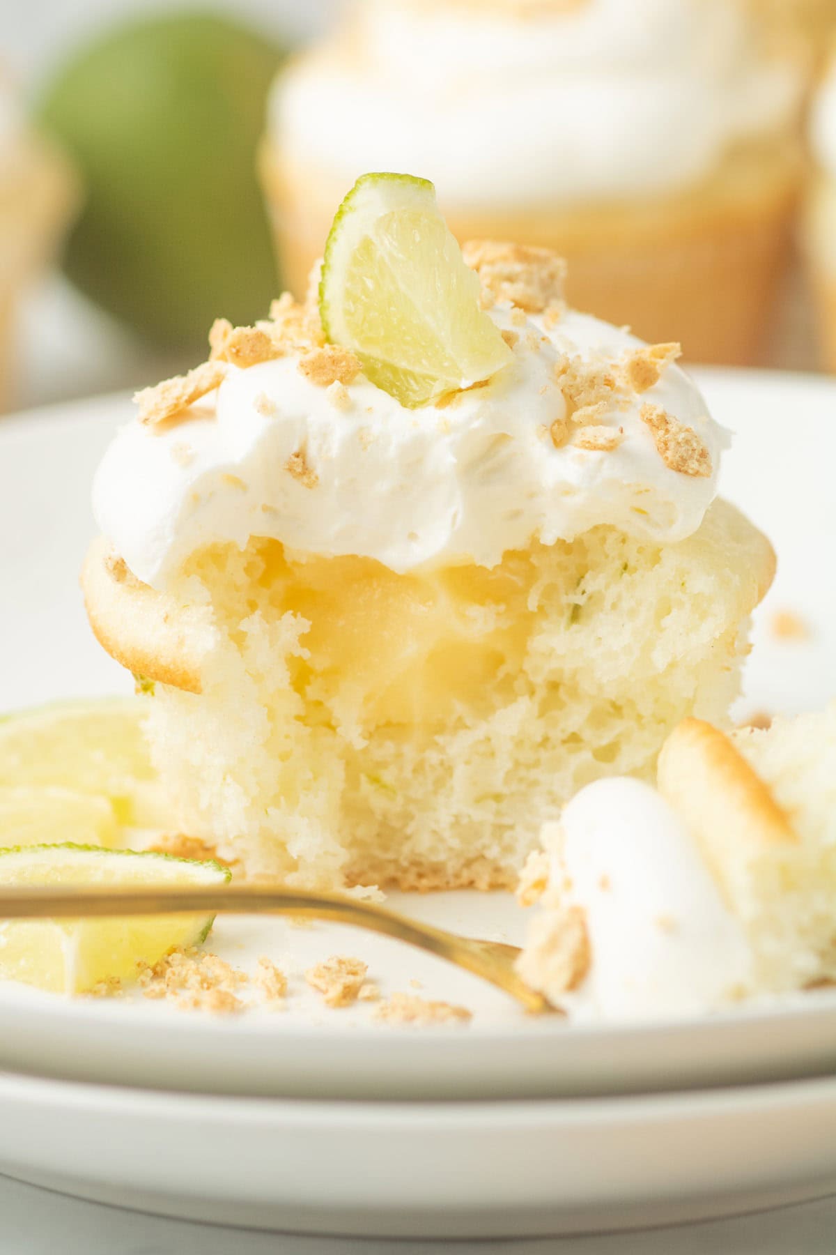 key lime pie cupcake cut in half showing the custard filling inside.