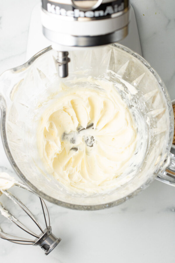 whipped cream cheese and powdered sugar in the bowl of a stand mixer.