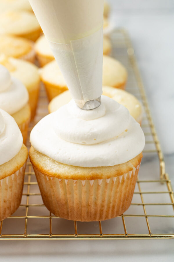 frosting whipped cream cheese frosting on a lime cupcake.