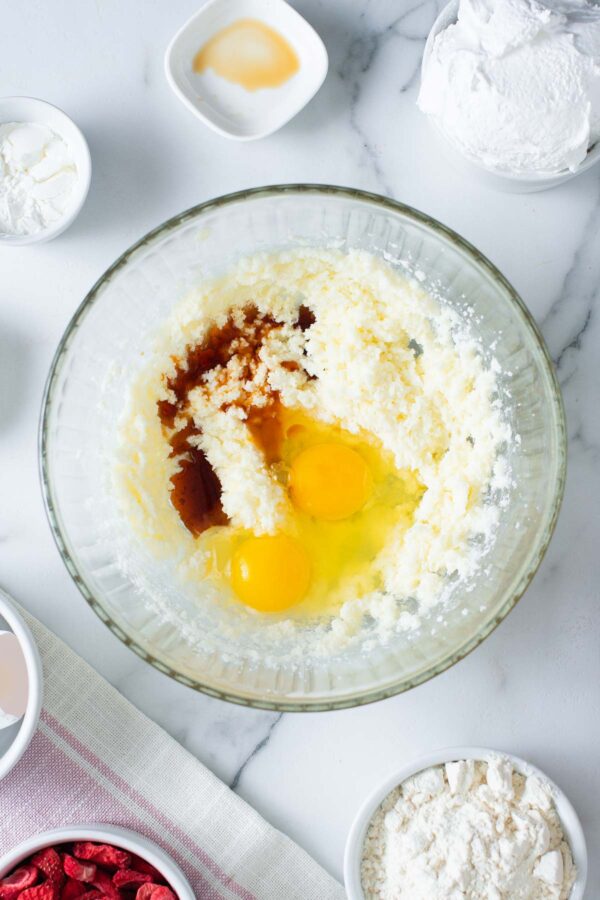 adding eggs and vanilla to creamed butter and sugar.
