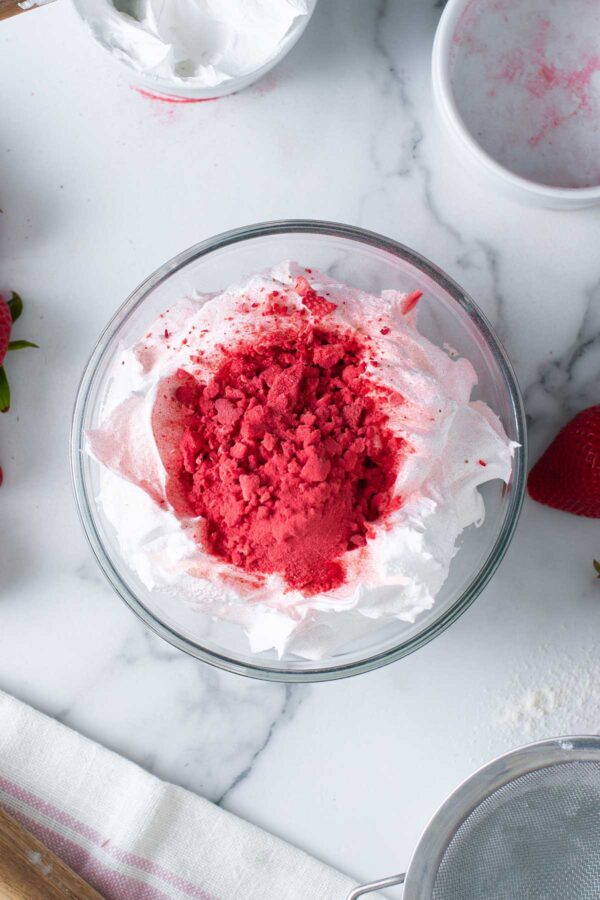 mixing freeze dried strawberry powder into vanilla frosting.
