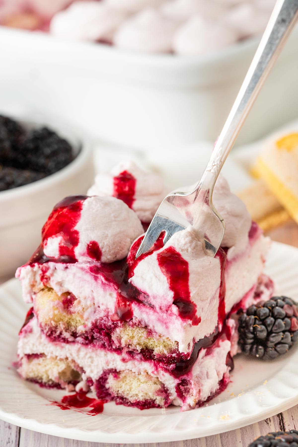 fork digging into a slice of blackberry tiramisu.