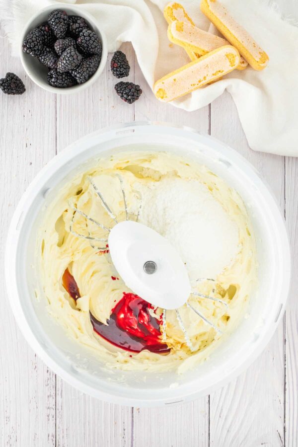 mascarpone and cream cheese with blackberry sauce in a mixer.