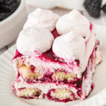 slice of layered blackberry tiramisu topped with blackberry sauce.