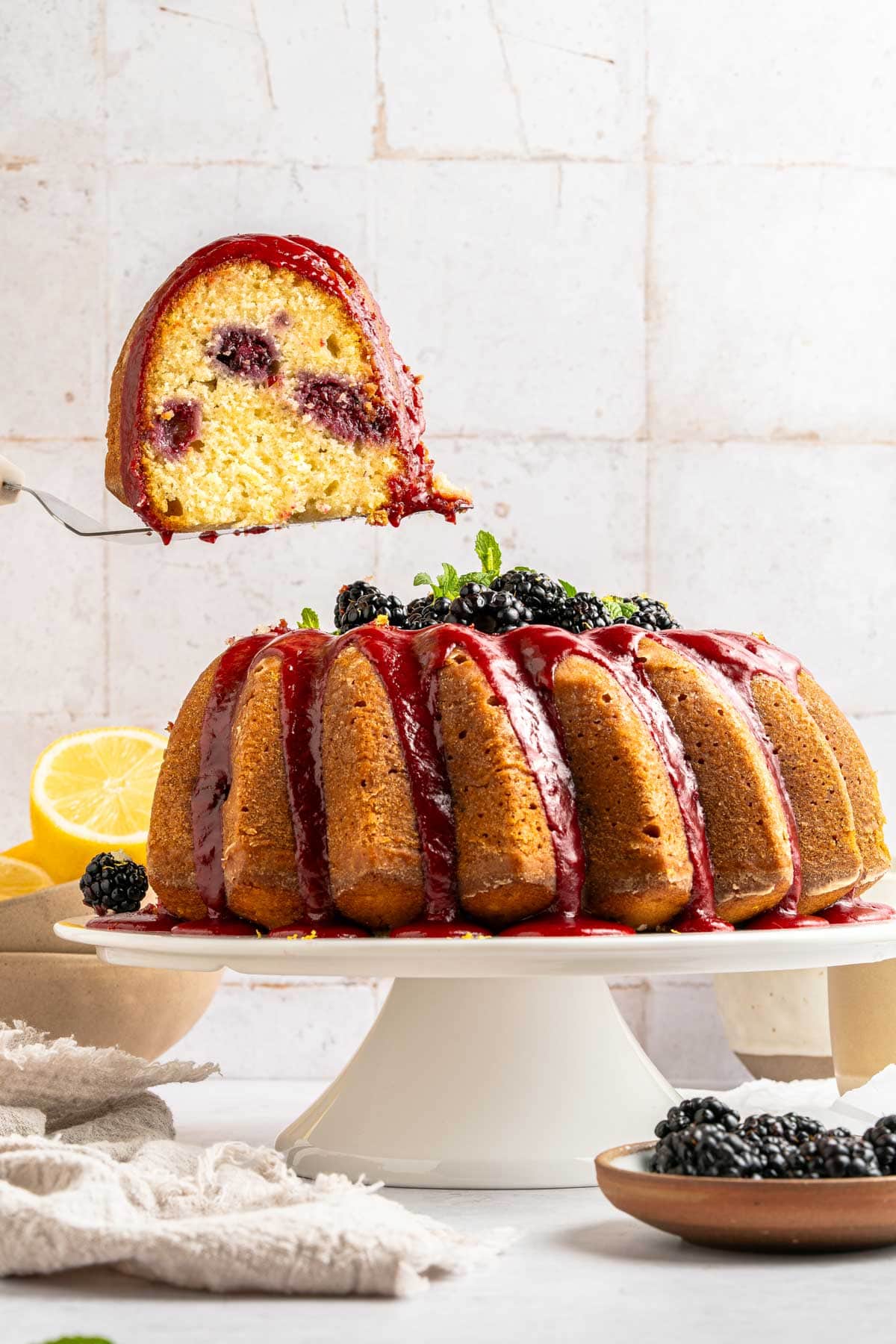 lifting a slice of bundt cake away from the rest of the cake.