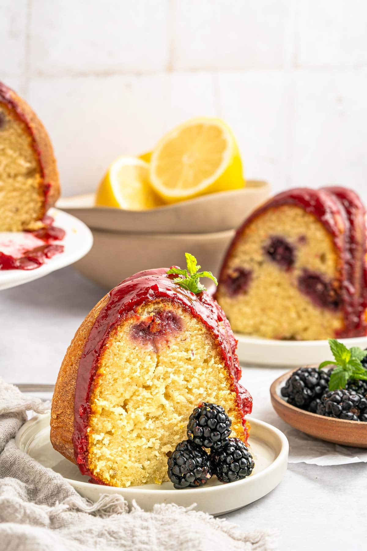 slice of bundt cake on a dessert plate with fresh blackberries.