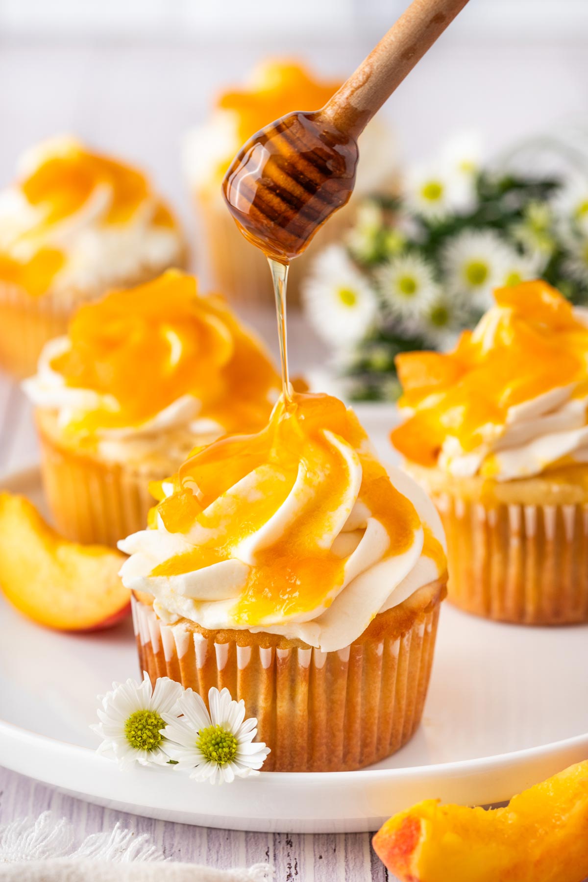 drizzling honey on top of frosted cupcakes.