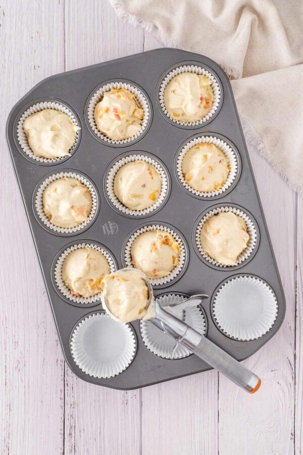 scooping cupcake batter into paper liners.