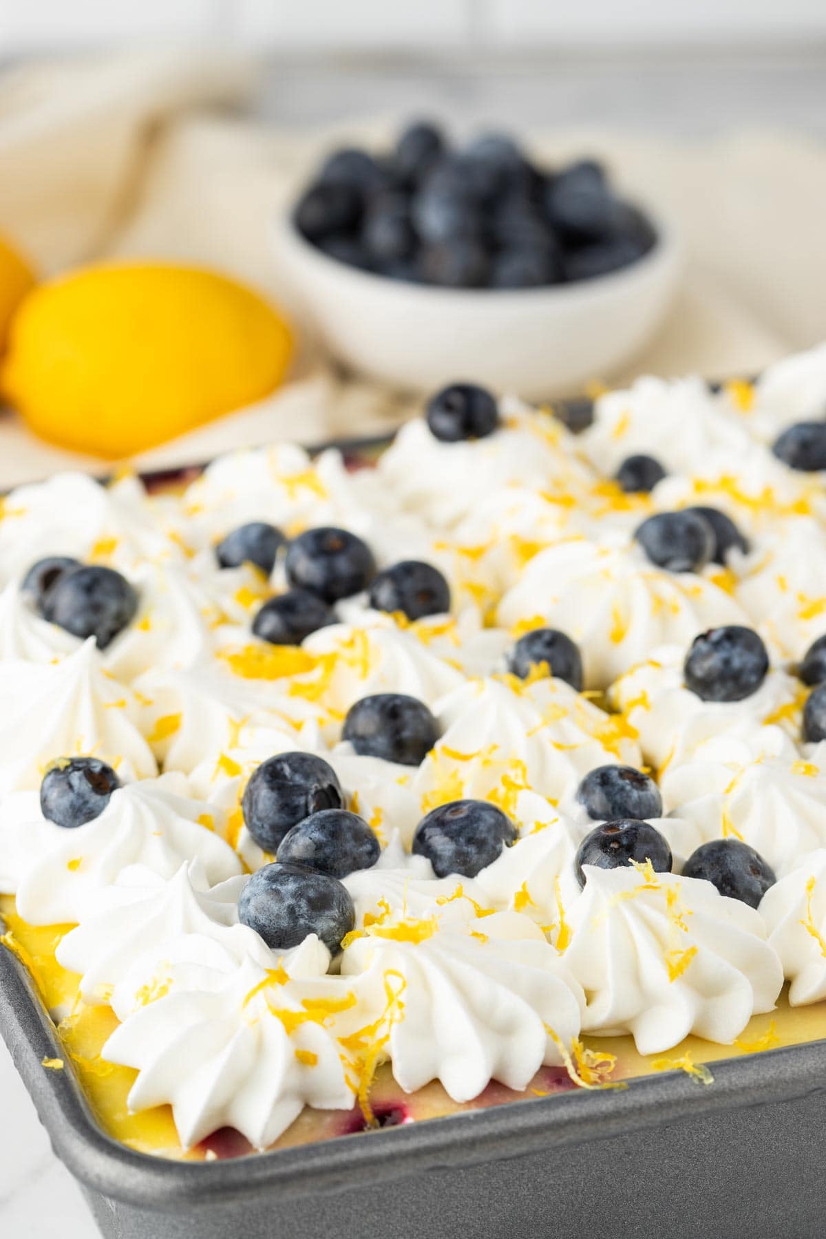 no bake cheesecake decorated with whipped cream, blueberries, and lemon zest.