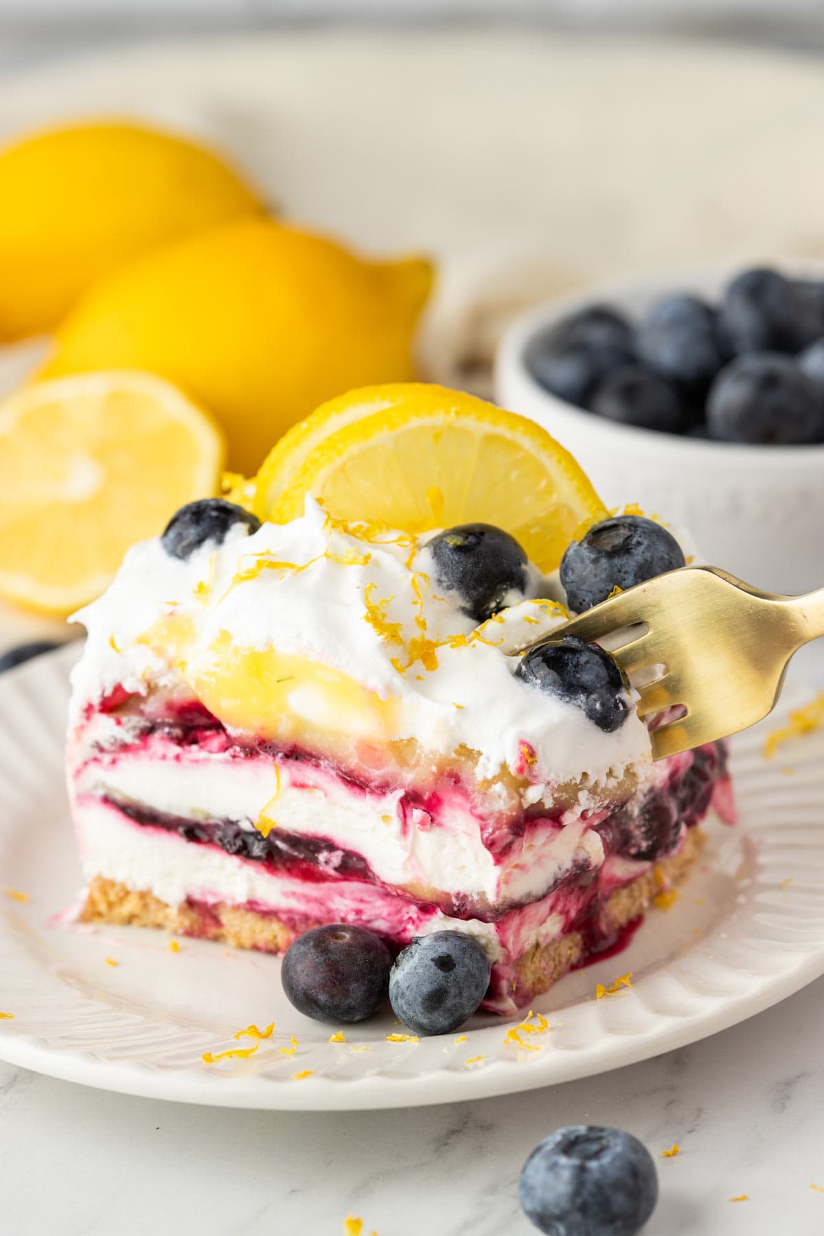 fork digging into a lemon blueberry no bake cream cake.
