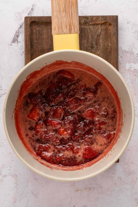 cooking down strawberries to make a strawberry puree.