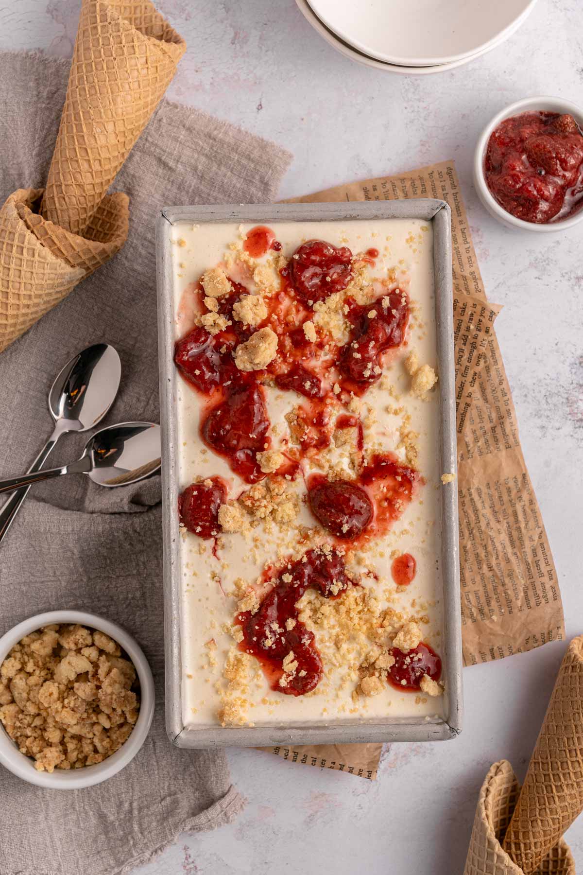 homemade strawberry shortcake ice cream layered in a metal loaf pan.