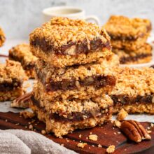 homemade date bars with an oat crust stacked vertically.